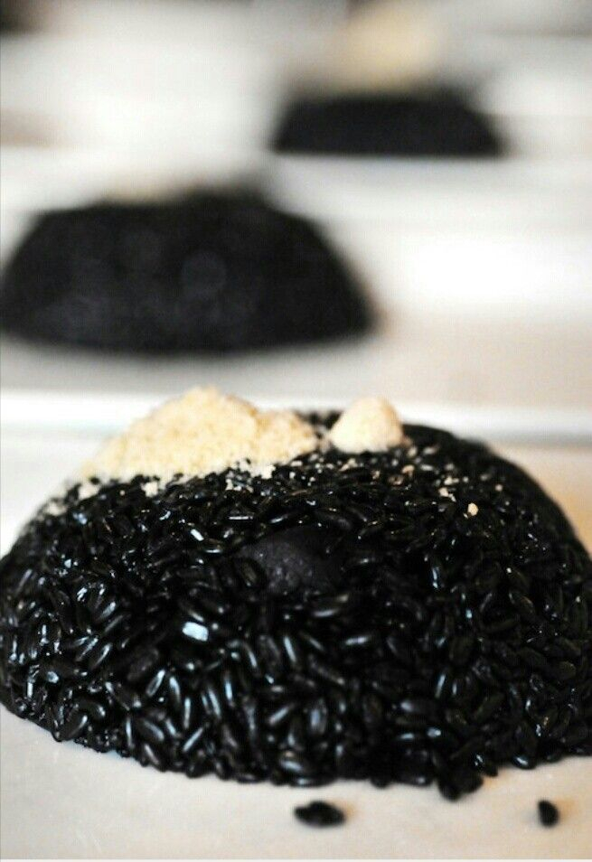 A Close Up Of A Doughnut With Black Sesame Sprinkles On It